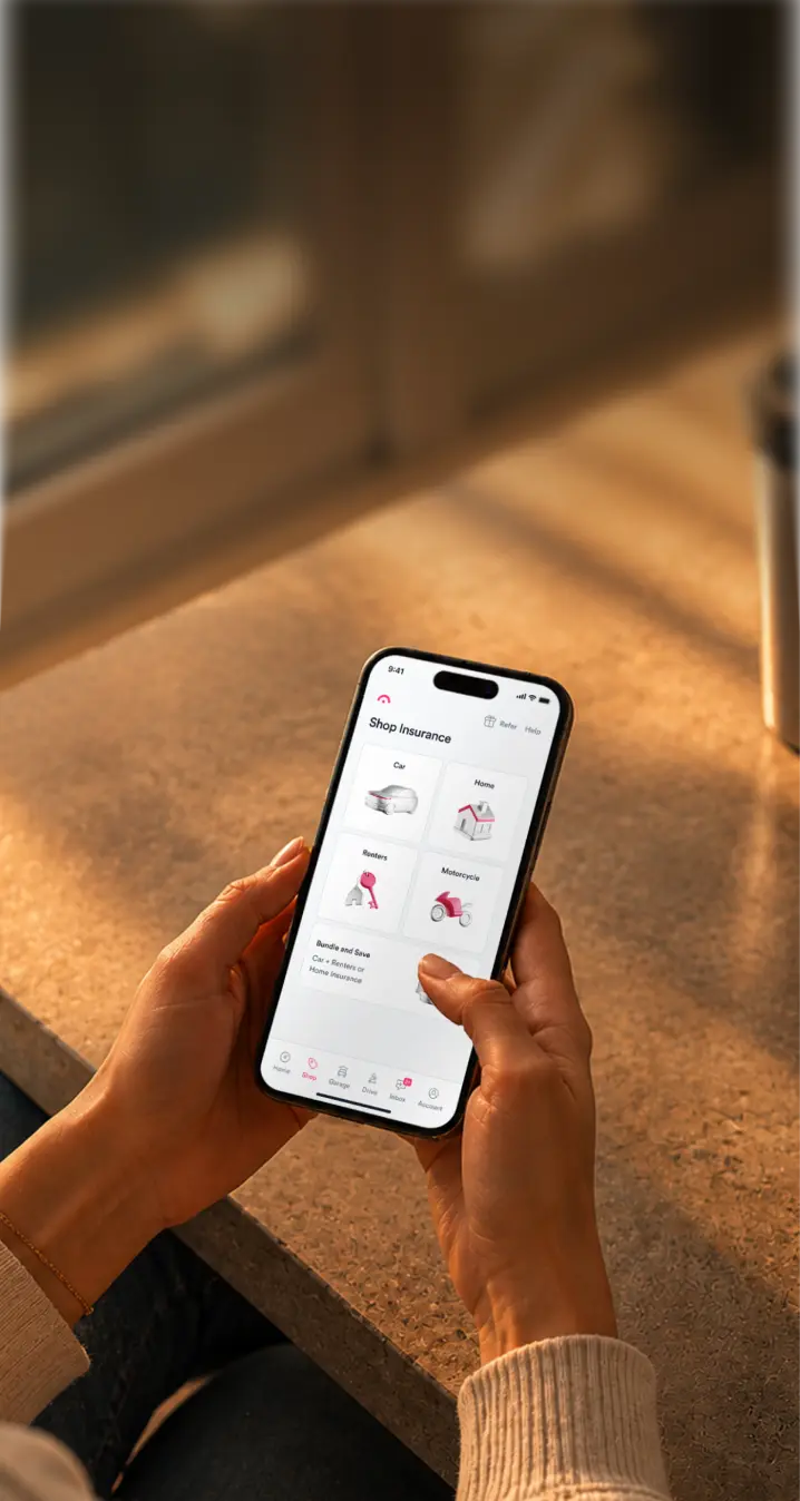 Someone holding a phone showing the Jerry app's Shop Insurance screen.